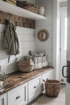 Cozy mudroom interior with bench seating, storage baskets, wall-mounted coat hooks and a shelf with folded blankets. Modern Farmhouse Basement Decor, Beachy Mudroom Ideas, Small Entry Mudroom Ideas, Simple Mudroom Ideas Entryway, Utility Porch, Farmhouse Mudroom Ideas, Cottage Mudroom, Farmhouse Mud Room, Basement Entry