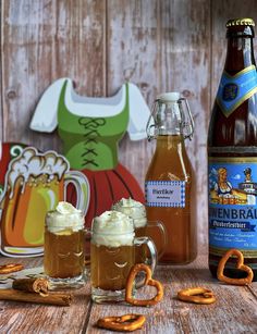 two mugs of beer and pretzels on a table with paper cutouts