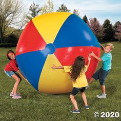 three children playing with a large inflatable ball