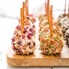 several appetizers are arranged on a cutting board with toothpicks sticking out of them