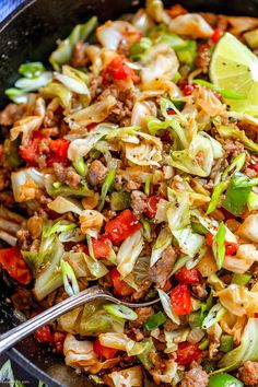 a skillet filled with stir fry vegetables and meats, ready to be eaten