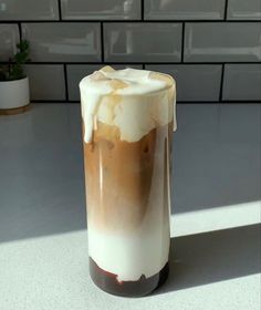 a tall glass filled with liquid sitting on top of a counter