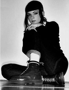 black and white photograph of a woman sitting on the floor with her hands under her chin