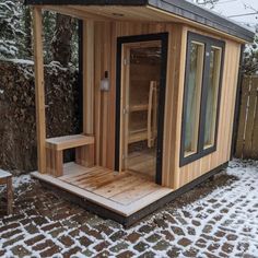 a small wooden sauna in the snow