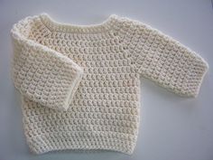 two white knitted sweaters sitting next to each other