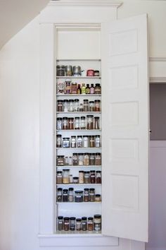 the pantry door is open to reveal an assortment of spices