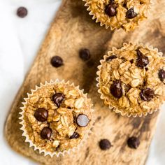 three chocolate chip muffins sitting on top of a cutting board