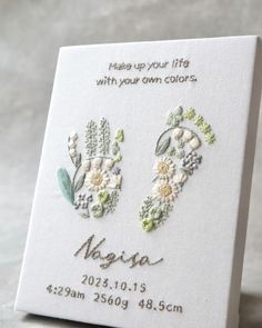 two embroidered flowers on a white card with the words, please up your life with your own colors