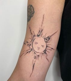 a woman's arm with a sun tattoo on it