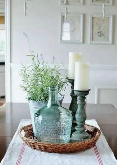 a table topped with two green vases filled with plants