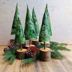 several green trees with pine cones and evergreen needles on top of each tree stump, sitting on a wooden table