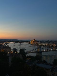 the city is lit up at night with lights on and bridges crossing over it in the distance