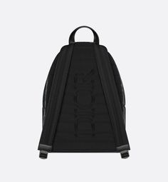 The Rider zipped backpack features a pared-down aesthetic, reminiscent of a classic school backpack. Crafted in black coated cotton canvas with the CD Diamond printed motif, it showcases Marc Bohan's 1974 graphic design reimagining the CD initials in the form of a diamond with architectural lines, and is accented by tonal smooth calfskin detailing and a Dior signature on the front. A two-way zip closure, a large zip pocket on the front and adjustable padded straps make this a quintessential bag Designer Black Nylon Backpack, Designer Black Coated Canvas Backpack, Designer Black Backpack For School, Black Coated Canvas Backpack With Zipper, Black Coated Canvas Backpack With Zipper Closure, Black Coated Canvas Backpack For School, Marc Bohan, Dior Star, Blanket Poncho