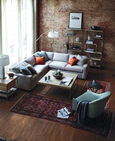 a living room filled with furniture and a brick wall behind the couch is a coffee table