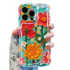 a woman holding up a phone case with flowers on it