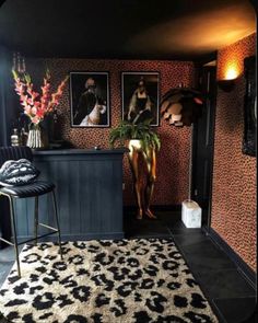 a living room filled with furniture and pictures on the wall next to a bar area