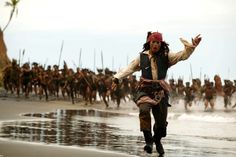 pirates running on the beach in front of a large group of men wearing pirate costumes