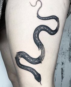 a woman's thigh with a snake tattoo on it