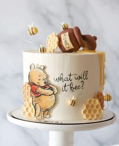 a winnie the pooh birthday cake with honeycombs on top and bees around it