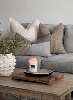 a coffee table with a candle and some pillows on it