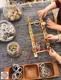 two children are playing with an abacus on the floor in front of other toys