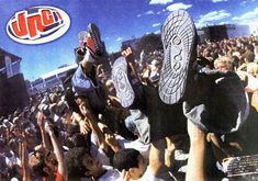 a group of people holding up skateboards in front of a crowd at a concert