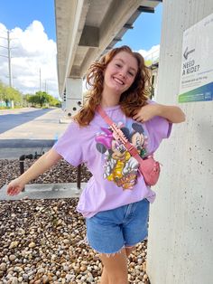 a girl standing next to a wall with her hand on her hip