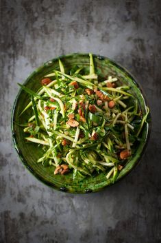 a green bowl filled with food on top of a table