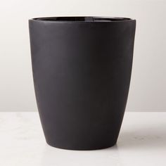 a black vase sitting on top of a white table