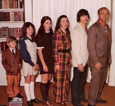 a group of people standing next to each other in front of a bookshelf