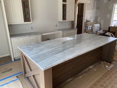 an empty kitchen with white cabinets and marble counter tops in the process of remodeling