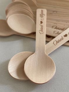 wooden spoons with engraved names on them sitting next to some personalized measuring spoons