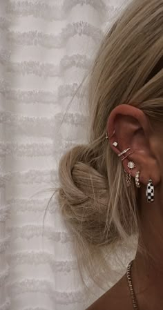 a woman with her hair in a bun and ear cuff