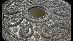 an ornate silver tray with lots of beads on the rim and sides, in front of a black background