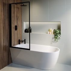 a white bath tub sitting in a bathroom next to a wooden shower door and wall