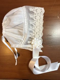 a white bra and ribbon on top of a wooden table