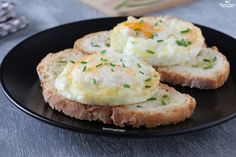 two pieces of bread topped with eggs on a black plate