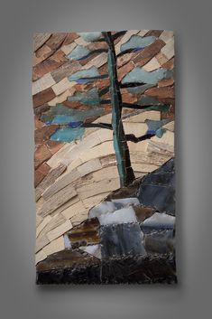 a tree made out of different types of wood and glass mosaics on a wall