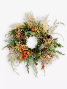 a christmas wreath with oranges and pine cones