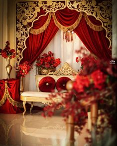 a room decorated with red curtains and gold trimmings