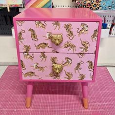 a pink dresser with gold tiger designs on it