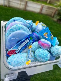 a cooler filled with candy and candies on top of it's side in the grass