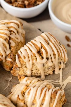 some kind of pastry with icing on it next to bowls of nuts and dip