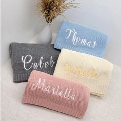 three personalized bath towels sitting on top of a white table next to a plant