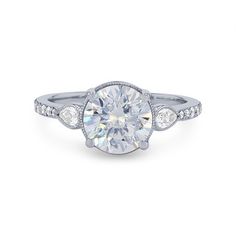 a white gold engagement ring with an oval cut diamond surrounded by three round brilliant diamonds