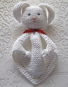 a crocheted white teddy bear with a red bow