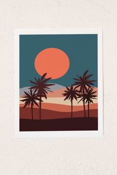 a sunset with palm trees in the foreground and an orange sun behind it on a white wall