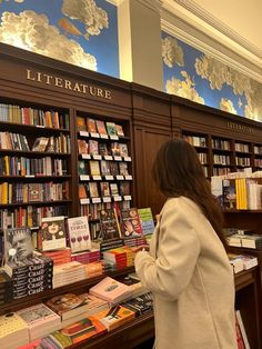 a woman standing in front of a library filled with books