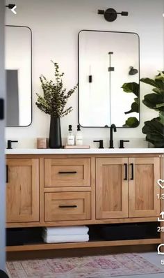 a bathroom vanity with two mirrors above it and a rug on the floor next to it