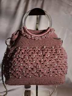 Pearl Pink Knitted Handbag with pink shoulder strap Introducing our exquisite Pearl Pink Knitted Handbag with pink shoulder strapp. This unique purse is a perfect blend of style and craftsmanship, meticulously crafted. The purse features a beautifully knitted design, adding a touch of elegance to any outfit. The intricate details highlight the skill and dedication put into creating this one-of-a-kind accessory. The silver shoulder strap adds a modern and chic element, allowing for easy and comfo Pink Crochet Satchel Bag With Adjustable Strap, Pink Crochet Shoulder Bag With Adjustable Strap, Pink Satchel Crochet Bag With Adjustable Strap, Chic Pink Crochet Bag With Adjustable Strap, Pink Double Handle Shoulder Bag As Fashion Accessory, Handmade Pink Crochet Shoulder Bag, Elegant Pink Crochet Bag For Everyday Use, Chic Pink Crochet Shoulder Bag, Pink Double Handle Crochet Bag